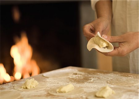 simsearch:649-09205909,k - Cook folding filled pasta in kitchen Foto de stock - Royalty Free Premium, Número: 614-08868424