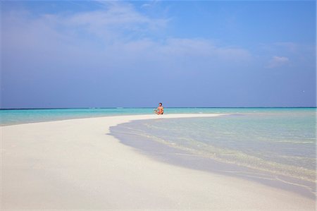 Man meditating on tropical beach Stock Photo - Premium Royalty-Free, Code: 614-08868623