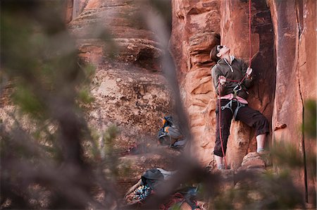 posição - Spotter holding rock climbers rope Foto de stock - Royalty Free Premium, Número: 614-08868716