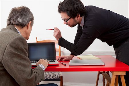 Businessmen working together on laptop Stock Photo - Premium Royalty-Free, Code: 614-08868729