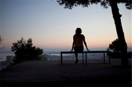 Woman admiring view from park bench Stock Photo - Premium Royalty-Free, Code: 614-08868749