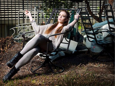 Woman smoking in lawn chair Stock Photo - Premium Royalty-Free, Code: 614-08868964