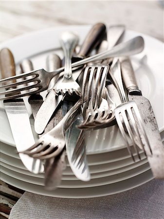 simsearch:689-03128420,k - Cutlery piled on stack of plates Fotografie stock - Premium Royalty-Free, Codice: 614-08869302