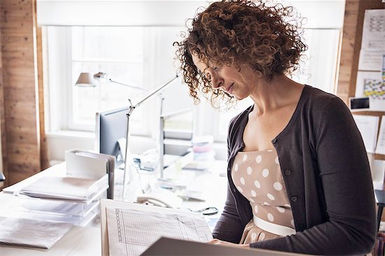 Businesswoman reading folder in office Photographie de stock - Premium Libres de Droits, Le code de l’image : 614-08869345