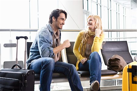 roll on luggage - Couple talking in airport waiting area Photographie de stock - Premium Libres de Droits, Code: 614-08869420