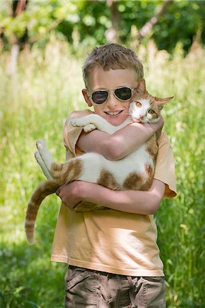 sunglasses field - Boy carrying cat outdoors Stock Photo - Premium Royalty-Free, Code: 614-08869519