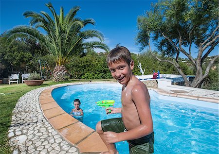 play swim girl photos - Boy climbing out of outdoor pool Stock Photo - Premium Royalty-Free, Code: 614-08869547