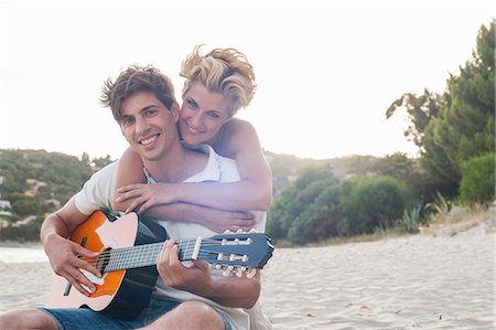 people in italy playing music - Smiling couple hugging on beach Stock Photo - Premium Royalty-Free, Code: 614-08869558