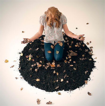 simsearch:633-02691266,k - Woman playing in pile of leaves and dirt Photographie de stock - Premium Libres de Droits, Code: 614-08869589