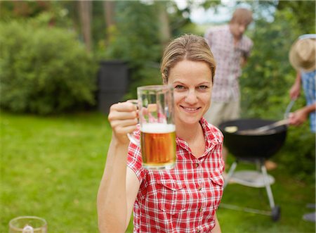 friends smiling 30 beer - Woman holding mug of beer outdoors Stock Photo - Premium Royalty-Free, Code: 614-08869687