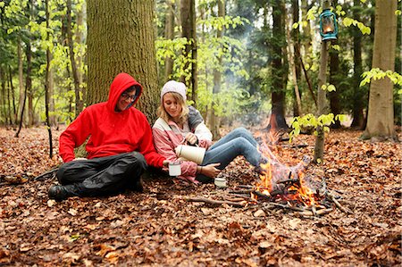Couple drinking coffee by campfire Stock Photo - Premium Royalty-Free, Code: 614-08869951