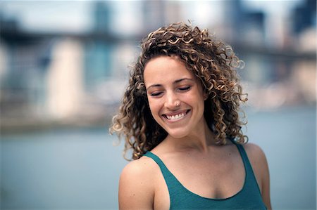 simsearch:614-08874111,k - Portrait of woman with curly hair, smiling Foto de stock - Royalty Free Premium, Número: 614-08874121