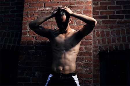 somnoliento - Man in front of brick wall, hands in hair Photographie de stock - Premium Libres de Droits, Code: 614-08874136