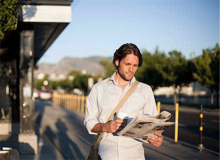 Man reading newspaper at railway station Foto de stock - Royalty Free Premium, Número: 614-08874203