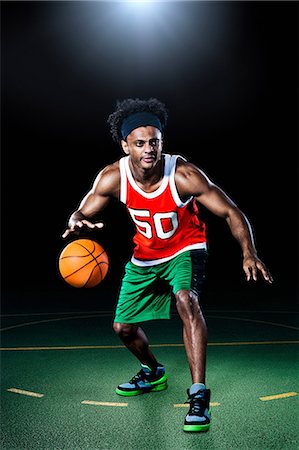 sports basketball portrait black background - Basketball player bouncing ball Stock Photo - Premium Royalty-Free, Code: 614-08874308