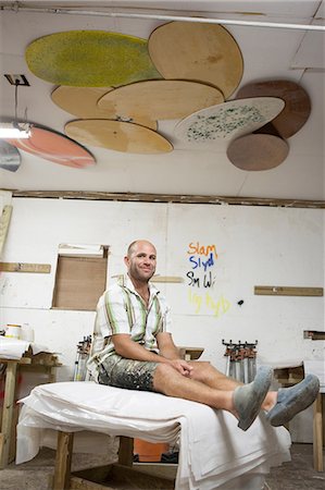 skimboard - Portrait of man sitting in skimboard workshop Foto de stock - Royalty Free Premium, Número: 614-08874316
