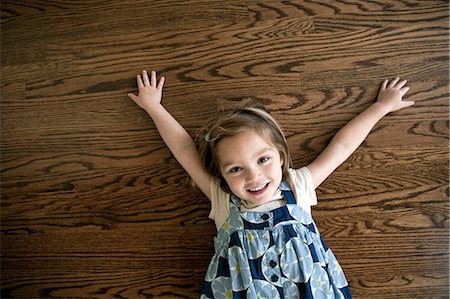 simsearch:6122-07696599,k - Little girl lying on wooden floor Photographie de stock - Premium Libres de Droits, Code: 614-08874356