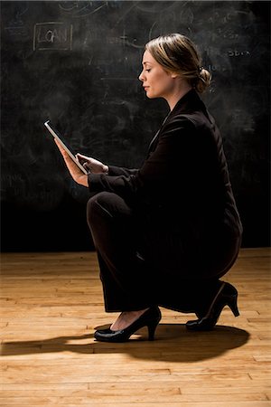 Woman by blackboard with digital tablet Stock Photo - Premium Royalty-Free, Code: 614-08874379