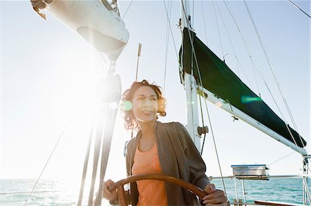 ship wheel - Young woman steering yacht Stock Photo - Premium Royalty-Free, Code: 614-08874538