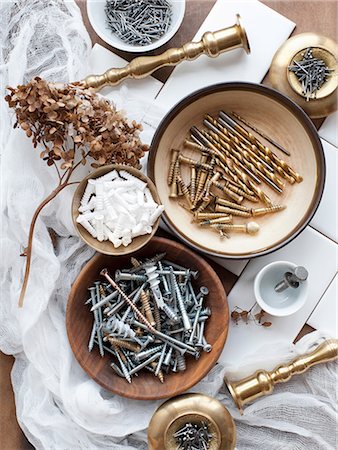 Still life of screws, nails and brass candlesticks Stock Photo - Premium Royalty-Free, Code: 614-08874962