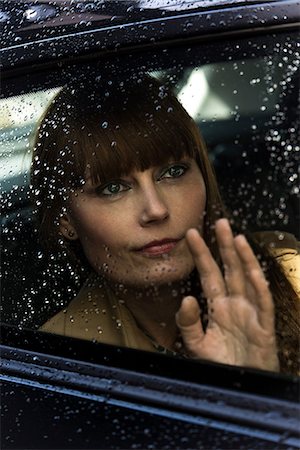 simsearch:6102-08885482,k - Woman waving and looking out of car window Foto de stock - Royalty Free Premium, Número: 614-08875024