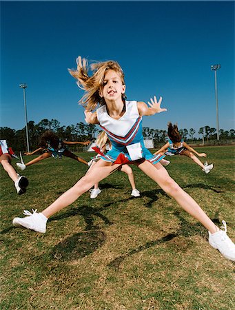 pre teens - Cheerleaders performing dance routine on sports field Stock Photo - Premium Royalty-Free, Code: 614-08875257