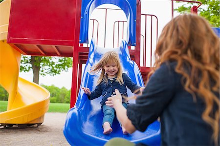 simsearch:614-08875430,k - Mother catching daughter at the bottom of slide Fotografie stock - Premium Royalty-Free, Codice: 614-08875417