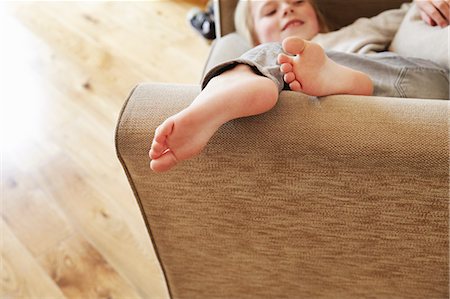 Young girl lying in armchair, portrait Stock Photo - Premium Royalty-Free, Code: 614-08875648