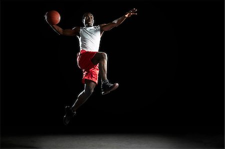 simsearch:622-05390906,k - Young male basketball player jumping with ball Stock Photo - Premium Royalty-Free, Code: 614-08875666