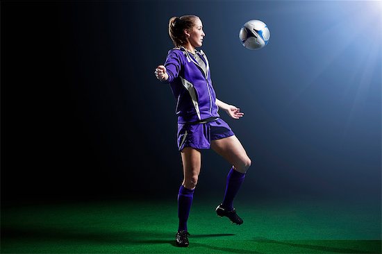 Young female soccer player with ball Stock Photo - Premium Royalty-Free, Image code: 614-08875684