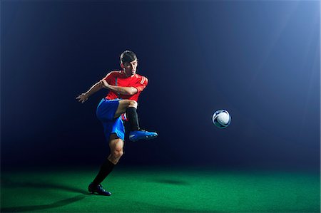 simsearch:649-03511270,k - Young male soccer player kicking ball Foto de stock - Sin royalties Premium, Código: 614-08875702