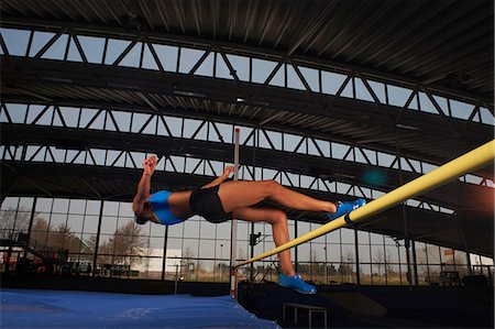 Young female athlete doing high jump Stock Photo - Premium Royalty-Free, Code: 614-08875900