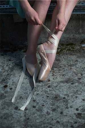 Ballet dancer tying ribbon on ballet shoe Foto de stock - Sin royalties Premium, Código: 614-08875941