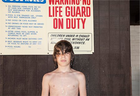 Portrait of boy with wet hair standing in front of hut Stock Photo - Premium Royalty-Free, Code: 614-08876314