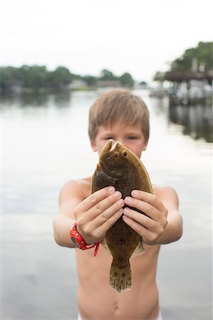 shirtless - Portrait of boy holding up flounder, Shalimar, Florida, USA Stock Photo - Premium Royalty-Free, Code: 614-08876318