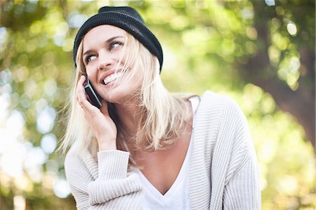 Young woman using mobile phone in park Stock Photo - Premium Royalty-Free, Code: 614-08876353