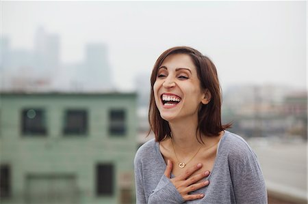 simsearch:6126-08635314,k - Woman laughing on city rooftop Stock Photo - Premium Royalty-Free, Code: 614-08876365