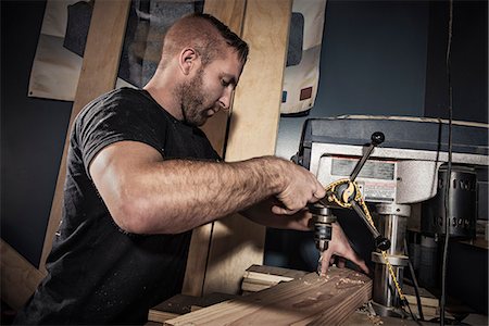 simsearch:614-08876584,k - Male carpenter drilling wooden plank in workshop Foto de stock - Royalty Free Premium, Número: 614-08876586