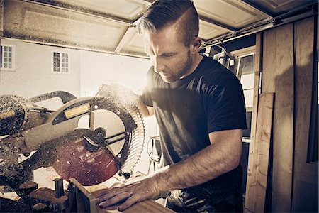 sciure - Male carpenter sawing plank of wood in workshop Photographie de stock - Premium Libres de Droits, Code: 614-08876589
