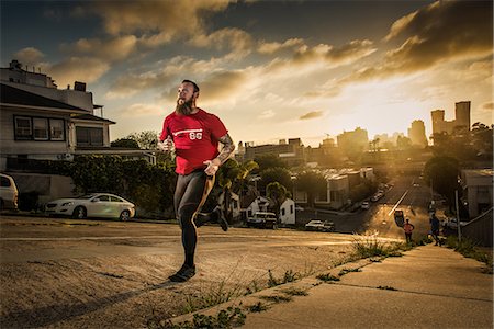 Mid adult male runner and team mates running up a steep city hill Stock Photo - Premium Royalty-Free, Code: 614-08876602