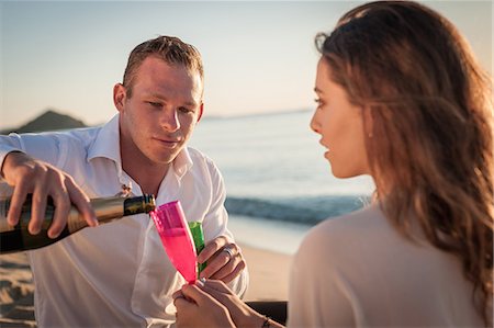 picture of champagne bottle and champagne flute - Young couple pouring champagne on beach, Castiadas, Sardinia, Italy Stock Photo - Premium Royalty-Free, Code: 614-08876720