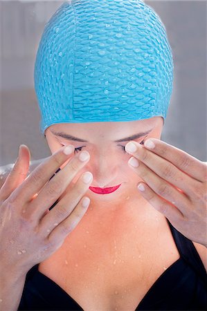 Close up portrait of young woman in swimming cap with hands over eyes Photographie de stock - Premium Libres de Droits, Code: 614-08876863