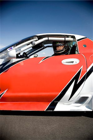 Portrait of racing car driver in racing car Foto de stock - Royalty Free Premium, Número: 614-08877040