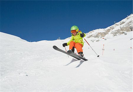 simsearch:6122-08229685,k - Young boy skiing down mountain, low angle view Fotografie stock - Premium Royalty-Free, Codice: 614-08877230