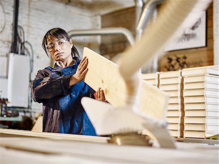 study board - Woman examining wood plank in printing workshop Stock Photo - Premium Royalty-Free, Code: 614-08877297