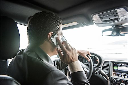 simsearch:614-06044348,k - Over the shoulder view of young businessman driving whilst talking on smartphone Foto de stock - Sin royalties Premium, Código: 614-08877313
