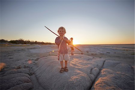 simsearch:862-03820213,k - Portrait of young boy standing on rock, holding spear, sunset, Gweta, makgadikgadi, Botswana Photographie de stock - Premium Libres de Droits, Code: 614-08877493