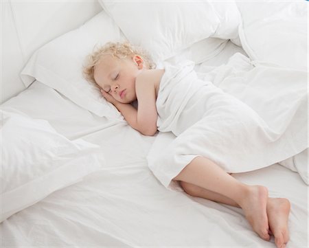 poulain - Young boy asleep on bed, under cover Photographie de stock - Premium Libres de Droits, Code: 614-08877590
