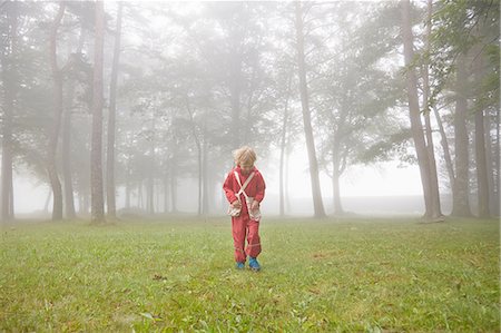 simsearch:614-08884796,k - Boy wearing red waterproofs searching in misty landscape Photographie de stock - Premium Libres de Droits, Code: 614-08877670
