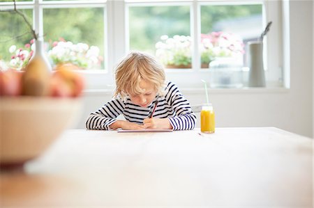 simsearch:614-08872573,k - Young boy sitting at table drawing on paper Stock Photo - Premium Royalty-Free, Code: 614-08877684